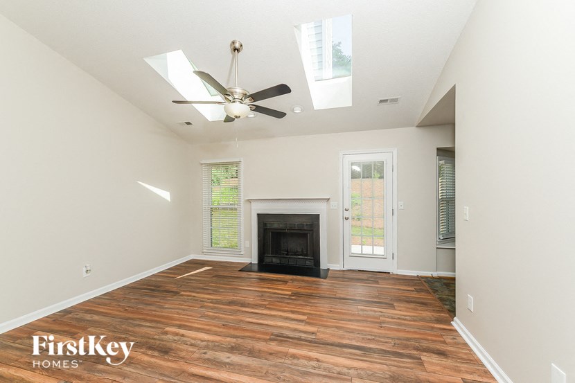 a living room with a fireplace and a ceiling fan