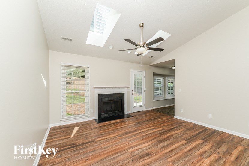 a living room with a fireplace and a ceiling fan