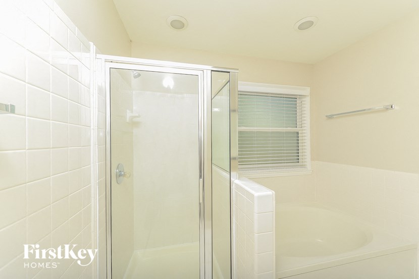 a white bathroom with a shower and a tub