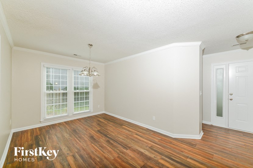 the living room of an empty house with wood flooring
