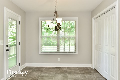 a dining room with a large window and a white door