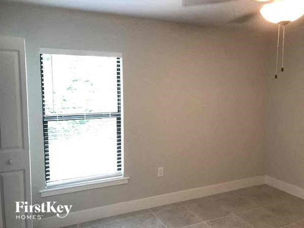 an empty living room with a window and a light