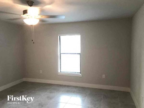 an empty room with a window and a ceiling fan