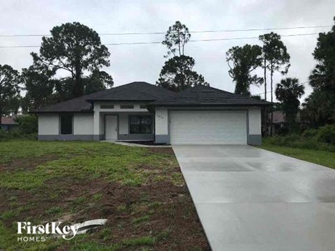 a small house with a yard and a driveway