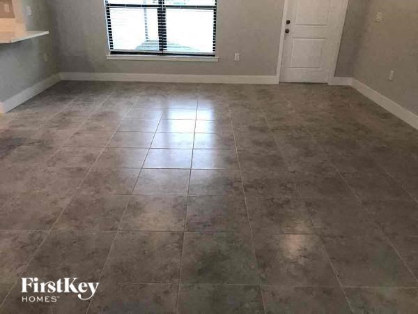 an empty room with tile flooring and a window