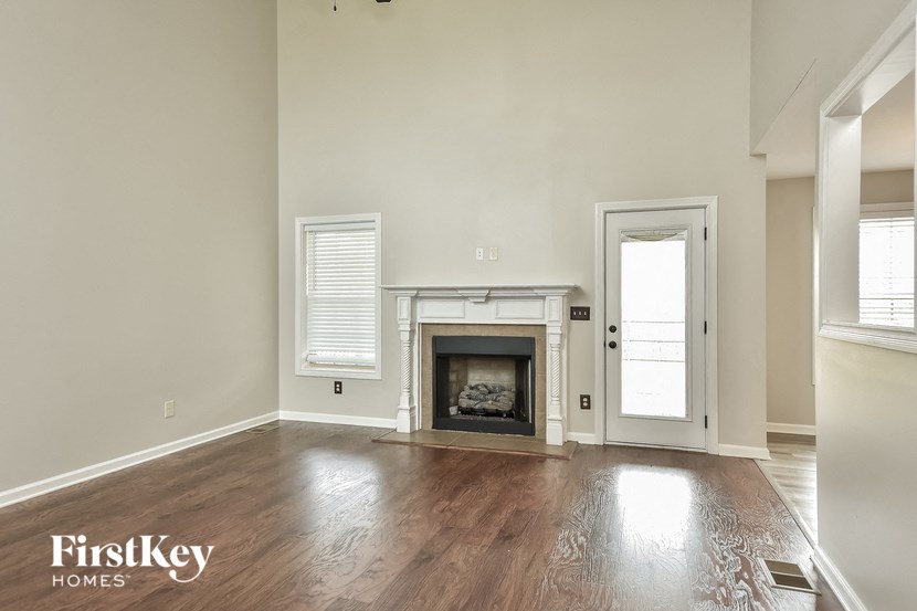 an empty living room with a fireplace and a door