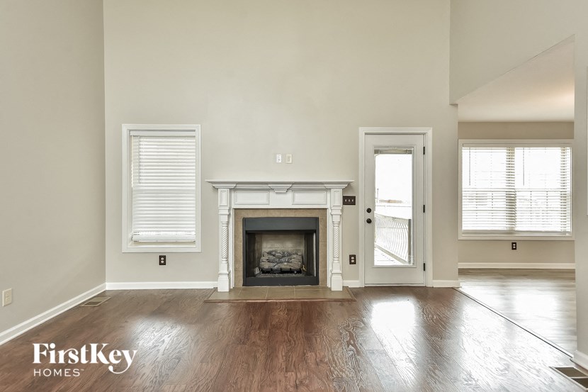 an empty living room with a fireplace and a door