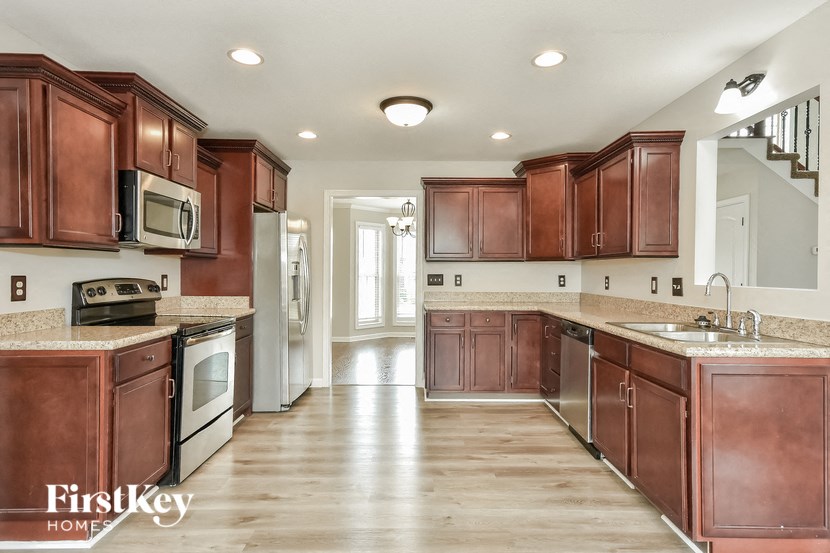 a large kitchen with wooden cabinets and stainless steel appliances