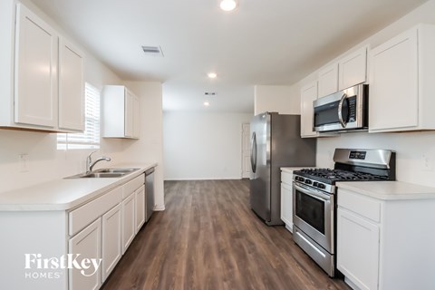 A kitchen with white cabinets and stainless steel appliances.