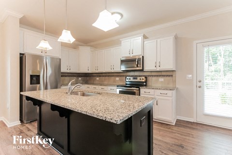 a kitchen with white cabinets and a granite counter top