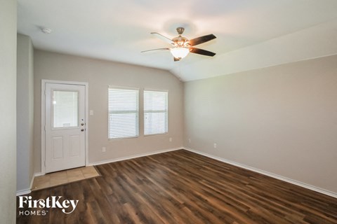 an empty room with a ceiling fan and a door