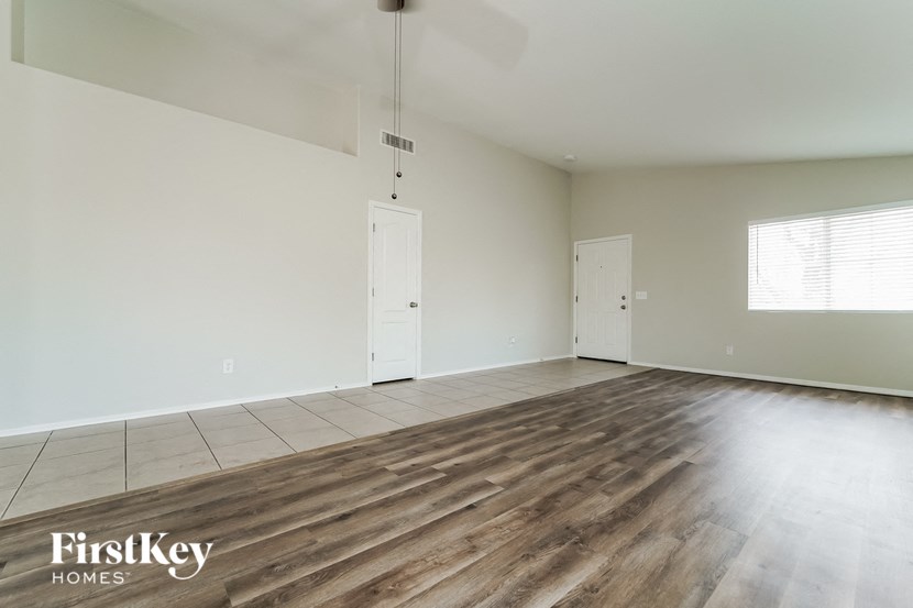 an empty living room with wood floors and white walls