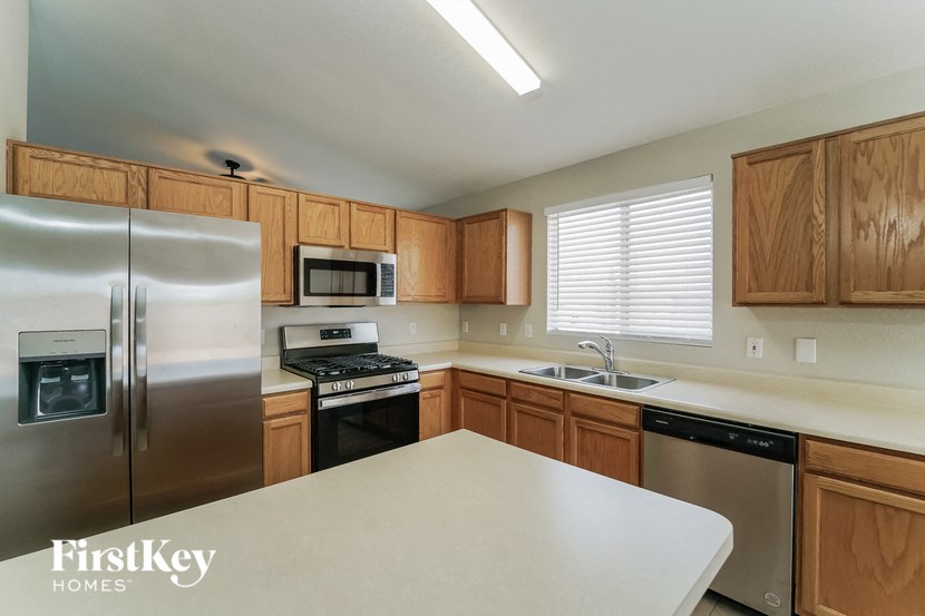 a kitchen with wooden cabinets and stainless steel appliances and a white counter top