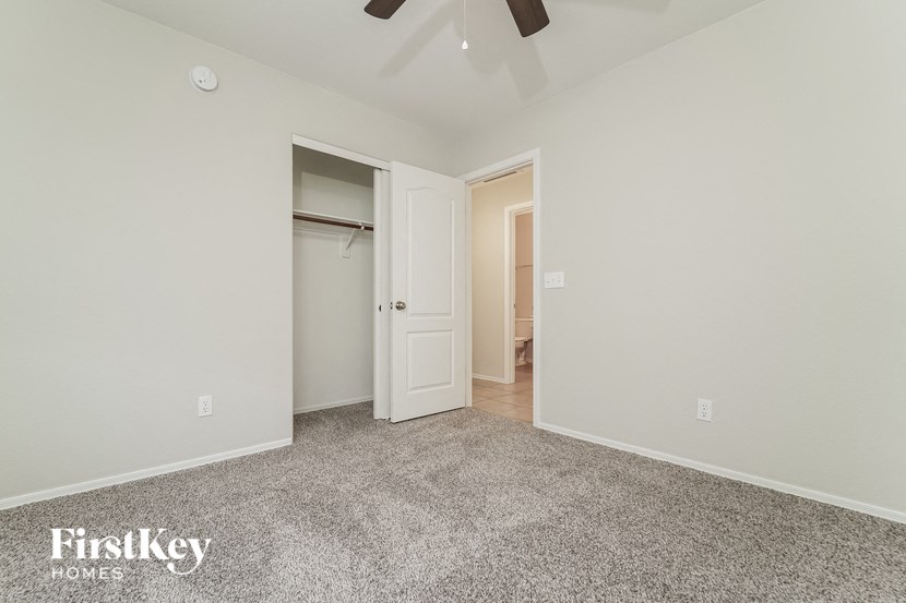 a bedroom with a closet and a ceiling fan