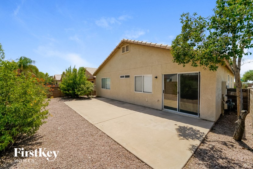 a tan house with a driveway and a glass door