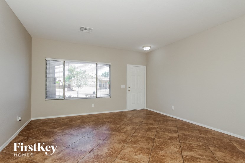 Empty room with brown tile flooring and a white door.