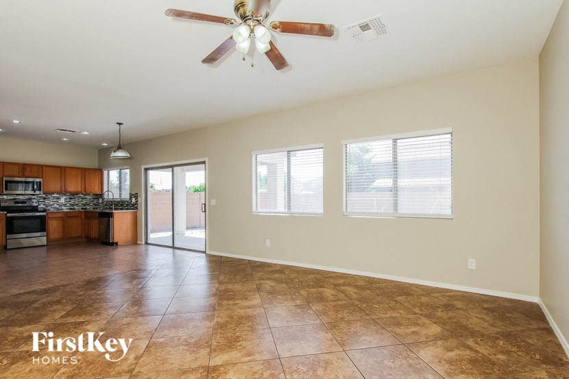 A spacious room with a ceiling fan and tiled floor.