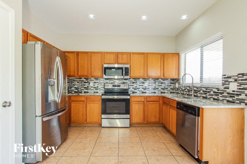 A kitchen with wooden cabinets and a stainless steel refrigerator.