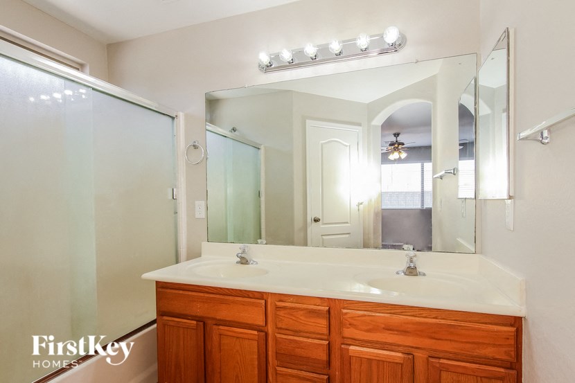 A bathroom with a double sink vanity and a mirror above it.