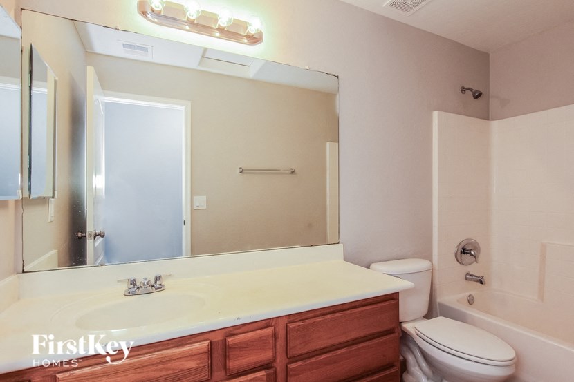 A bathroom with a white countertop and a wooden drawer.