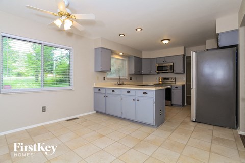 a large kitchen with blue cabinets and a large window