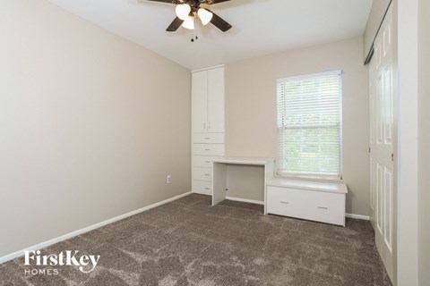 a bedroom with a desk and a window