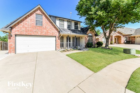 a clean driveway in front of a house with a white garage door