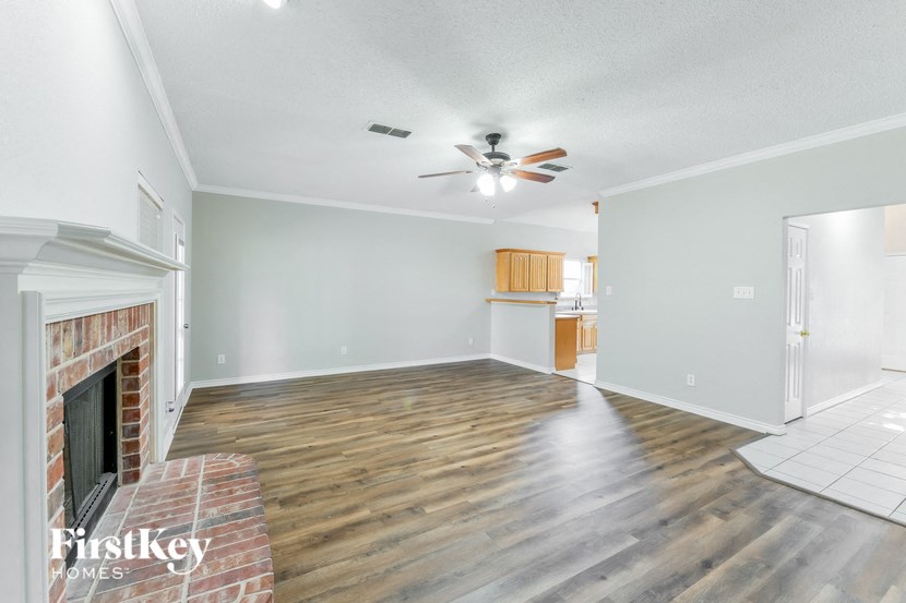 a living room with a fireplace and a ceiling fan