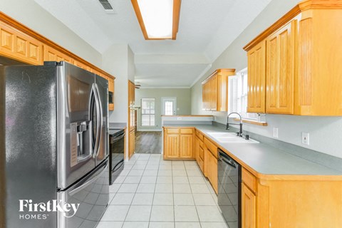 a kitchen with wooden cabinets and a stainless steel refrigerator