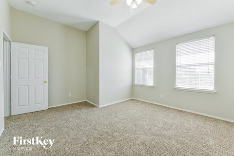 a bedroom with carpet and a white door and window