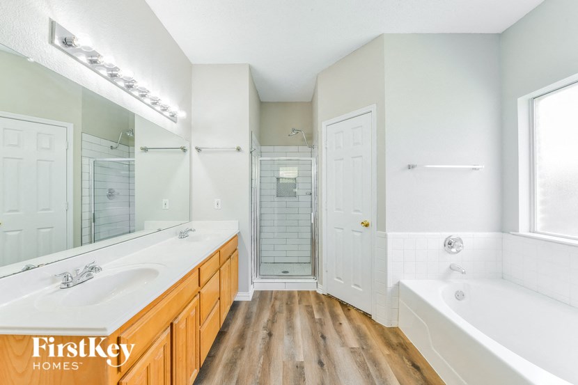 a bathroom with a tub and a sink and a mirror