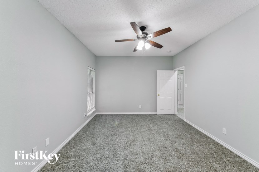 the living room of a house with a ceiling fan