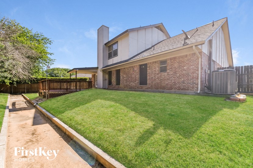 a backyard with a house and a lawn