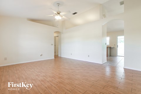 an empty living room with white walls and wood floors