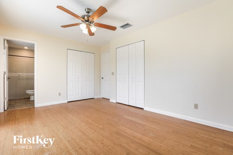a living room with a wood floor and a ceiling fan