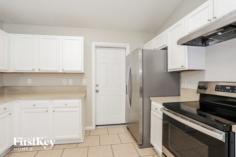 a kitchen with white cabinets and stainless steel appliances