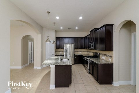 a large kitchen with black cabinets and stainless steel appliances