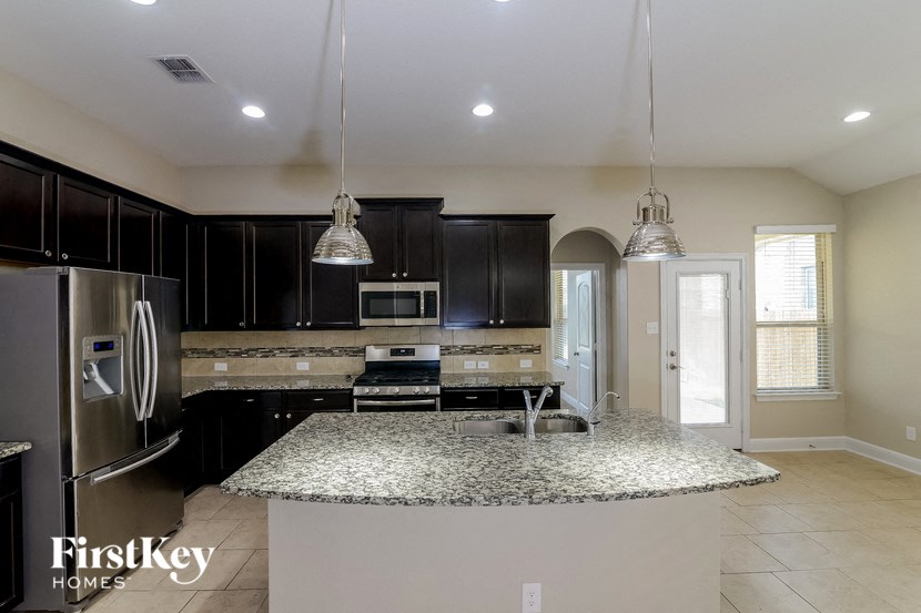 a kitchen with black cabinets and a granite counter top