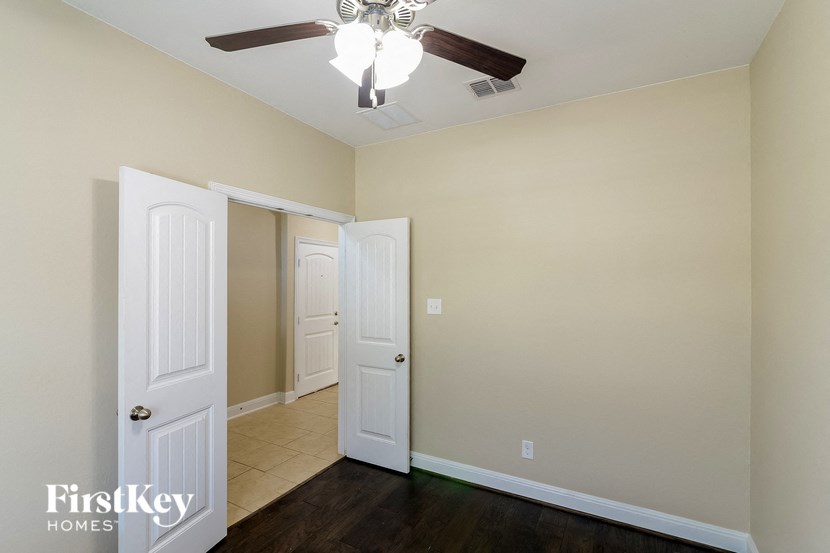 a bedroom with a ceiling fan and a door to a closet