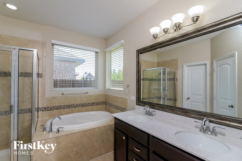 a bathroom with a tub and a sink and a mirror