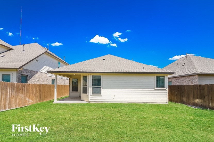 a small white house with a yard and a fence