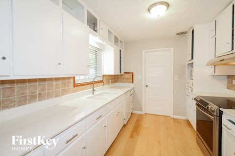 A kitchen with white cabinets and a tile backsplash.