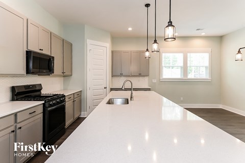 A kitchen with a white countertop and a stove top oven.