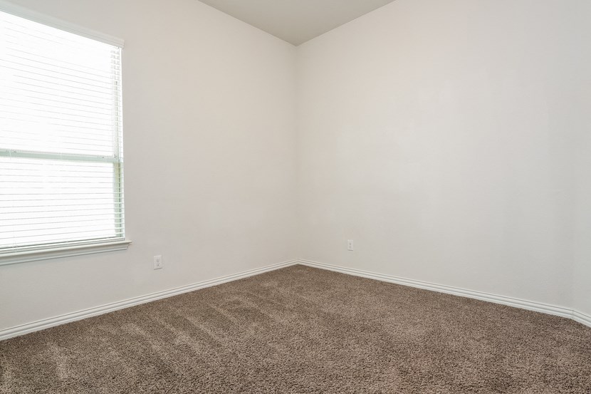 an empty room with carpet and a window