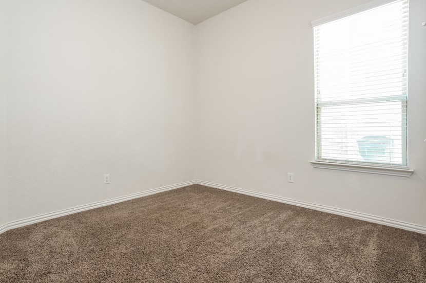 an empty room with carpet and a window