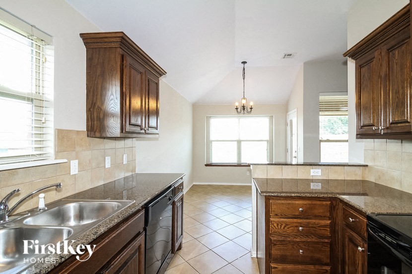 a kitchen with wooden cabinets and a stainless steel sink
