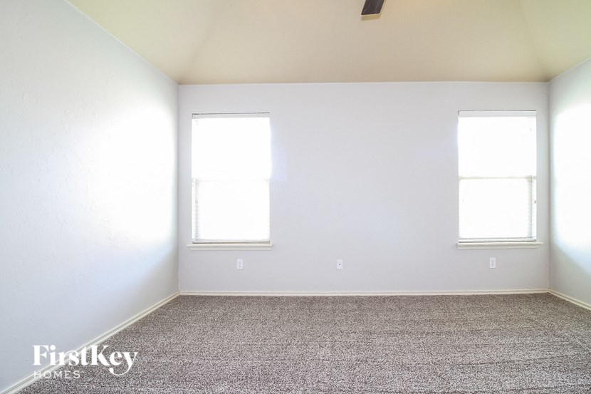 a white room with two windows and a carpet