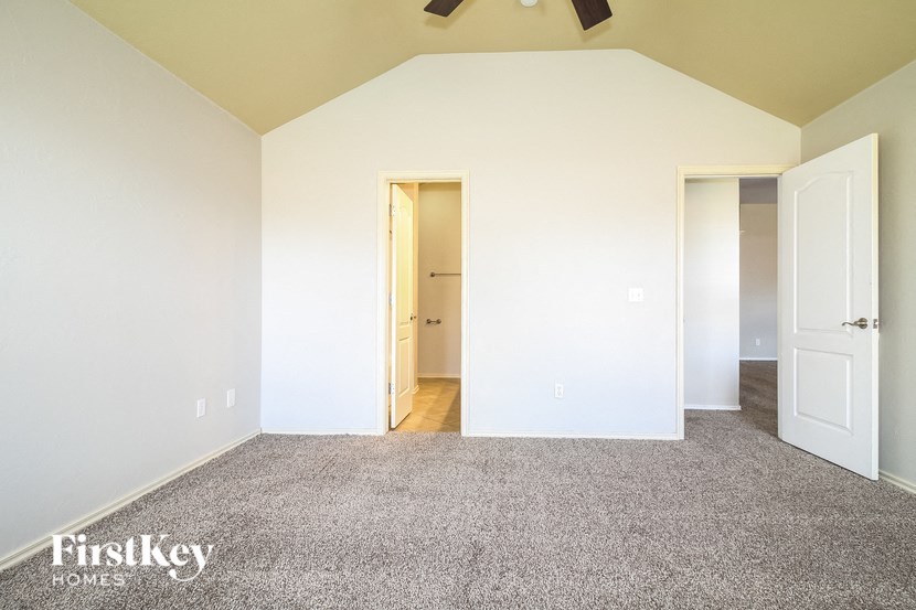 an empty room with carpet and a door to a closet