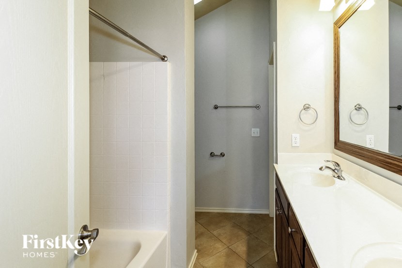 a bathroom with a shower and a sink and a mirror