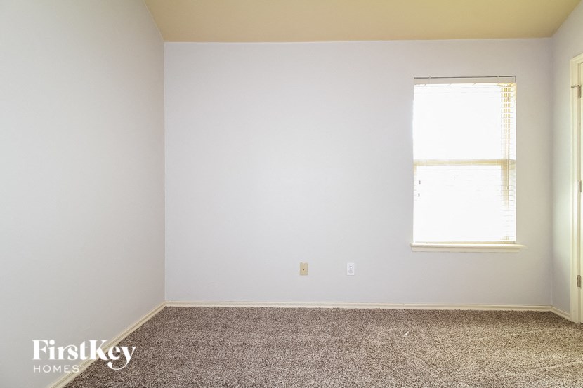 a white room with a window and a carpeted floor